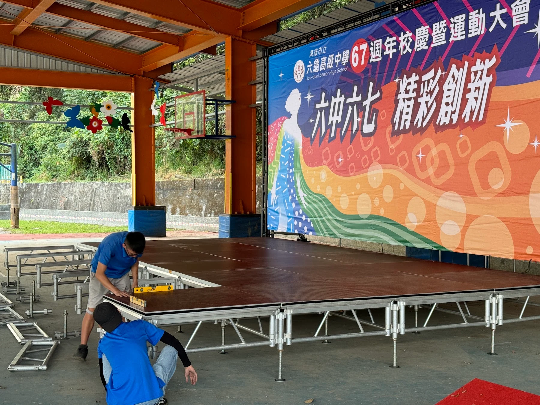 都市彩繪工作人員使用水平尺搭設活動舞台